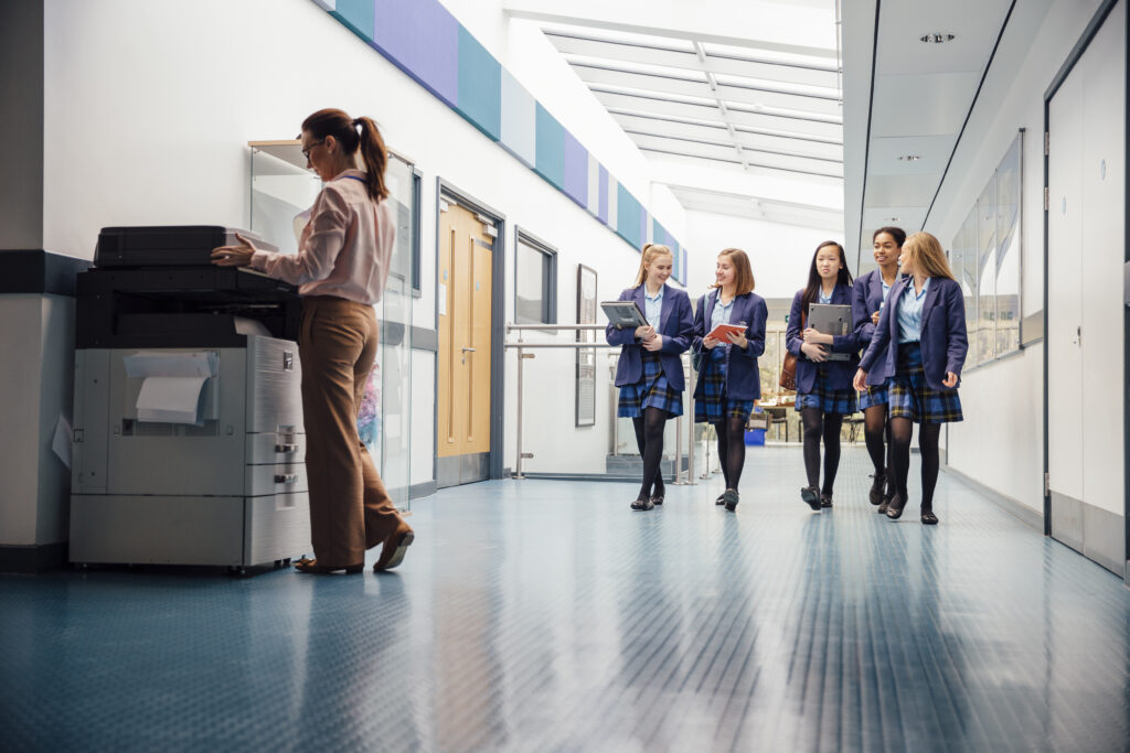 Switching Managed Print Providers For Schools group,of,teenage,girls,are,walking,down,the,school,hall